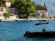Zgrade na obali Kotora, more i čamac.