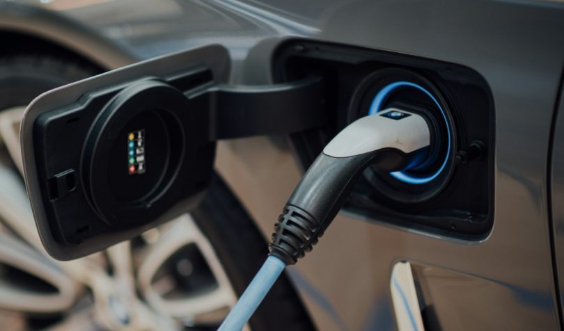 Crno-beli punjač priključen za električni automobil