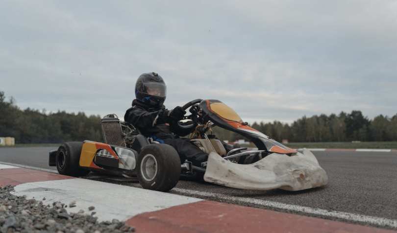 Osoba u go-kart vozilu na stazi.