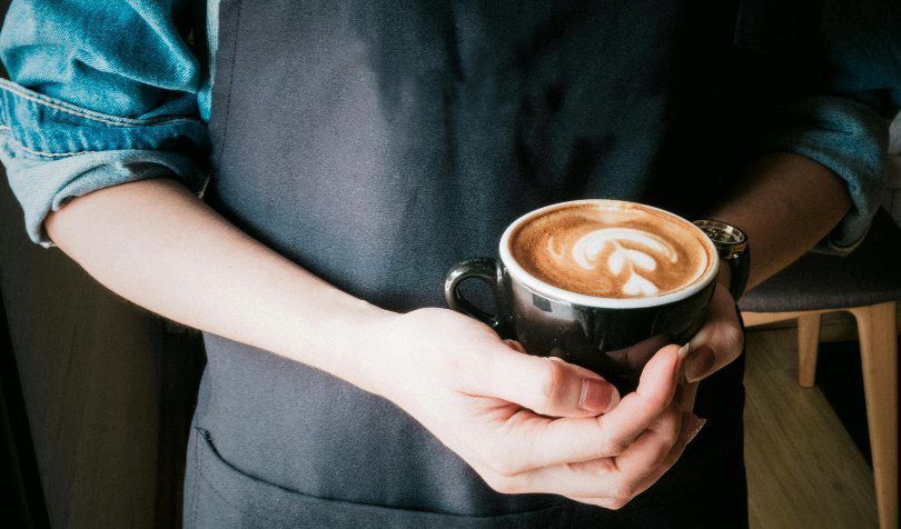 Barista drži kapućino u rukama