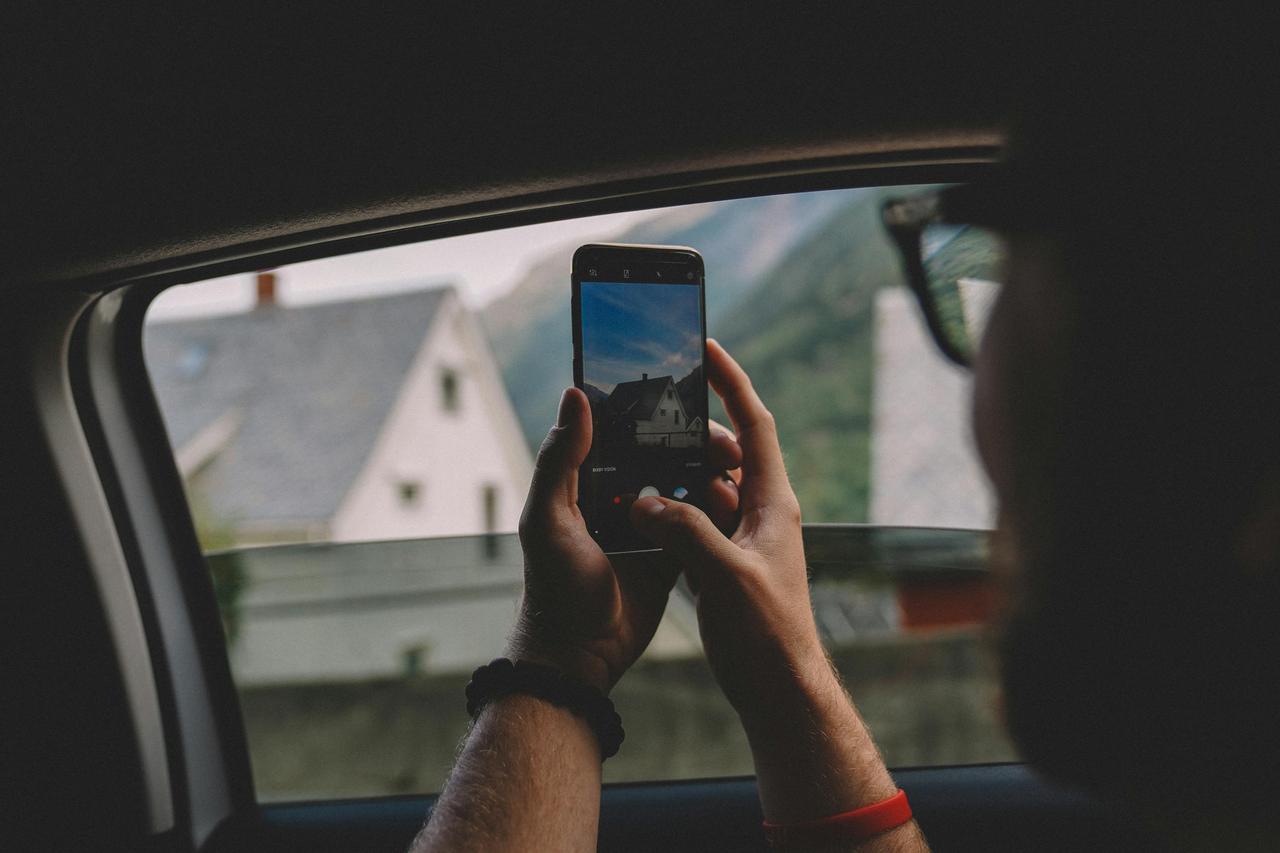 Čovek fotografiše auto telefonom