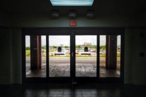 Pogled kroz staklena vrata na parking i automobile