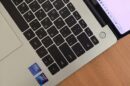 Tastatura laptopa sa ćiriličnim tasterima i nalepnicama procesora na drvenom stolu.
