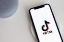 Telefon na stolu, a na kojem je uključena aplikacija Tiktok