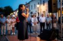 Žena peva u mikrofon na otvorenom događaju pred publikom